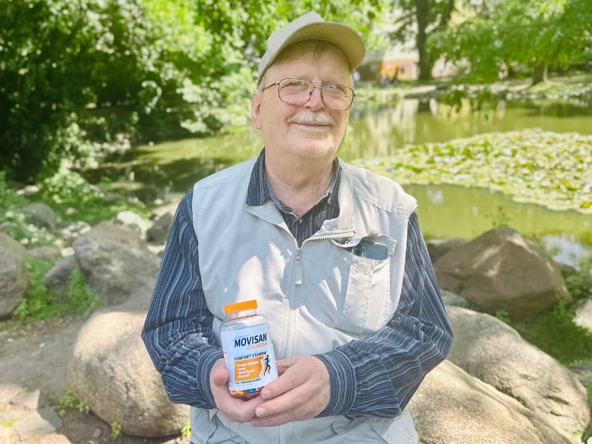 Natural Pharmaceuticals Movisan® Collagen II Starszy mężczyzna w czapce i kamizelce pokazuje suplement diety Movisan Collagen dla komfortu stawów na tle parku.